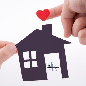 Couple standing together by a window forming a heart with their hands, symbolizing loving where you live in West Tennessee
